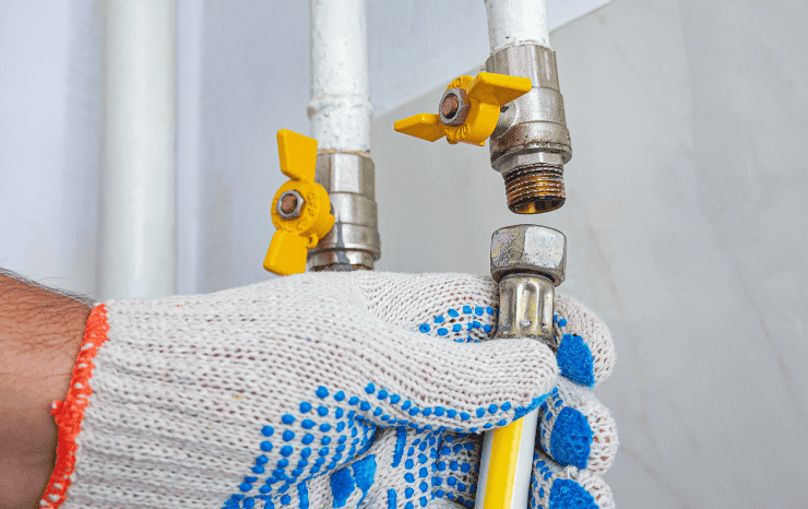 main d'un ouvrier en train de faire un raccordement gaz